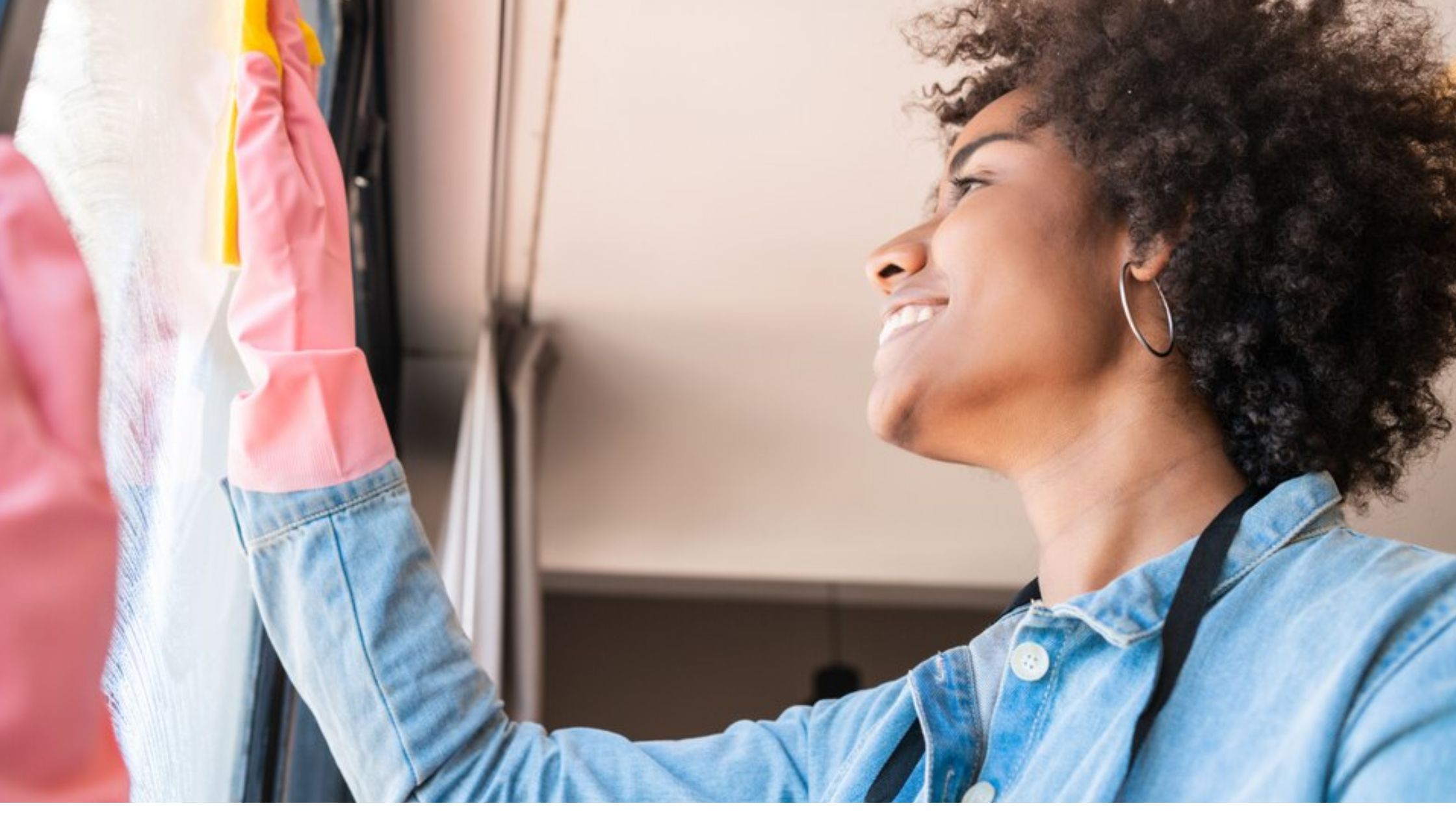 woman cleaning window with rag at home
