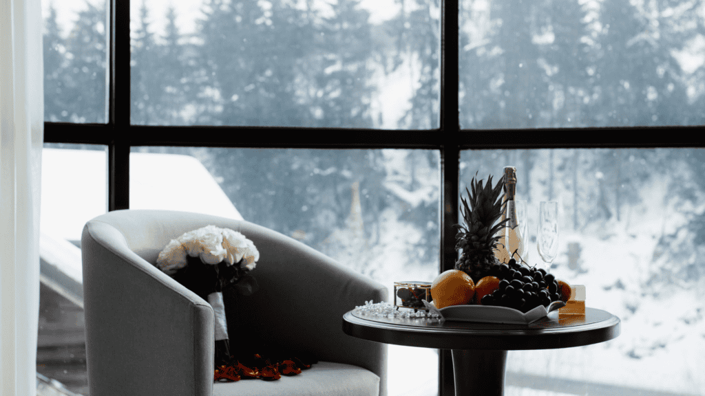 A cozy, warmly lit room with a snow-covered window